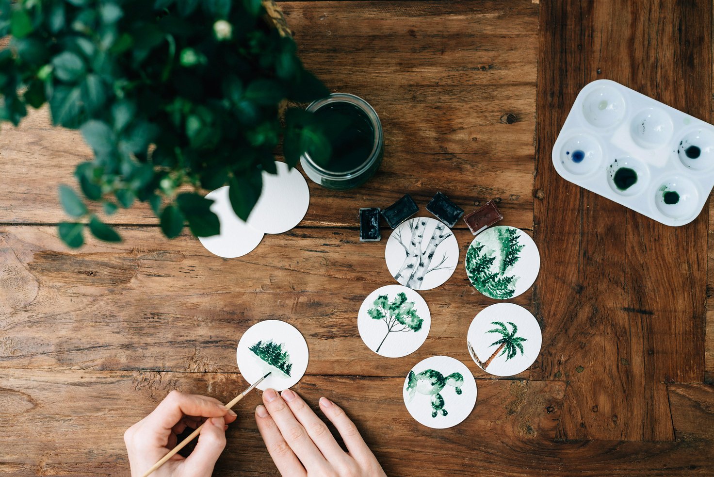 Unrecognizable Hands Painting on Wooden Table